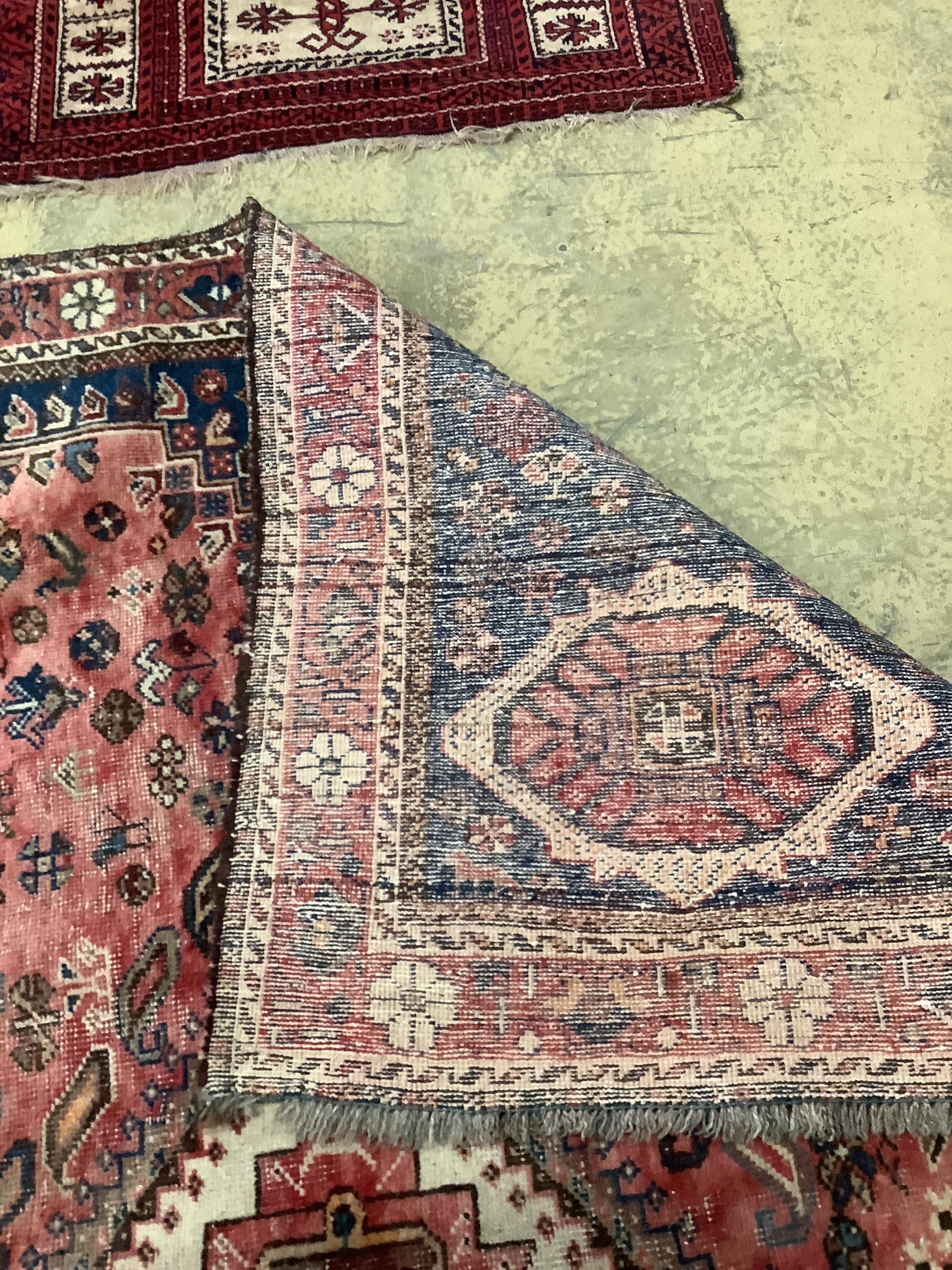 A North West Persian red ground carpet and a Belouch prayer rug, larger 300 x 216cm